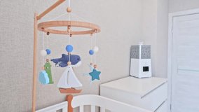 serene nursery with a wooden baby mobile featuring a whale, sailboat, starfish, and lighthouse. Soft blue tones, white crib, humidifier on dresser — calm, modern, nautical theme - Powered by Shutterstock - Get 15% off with code: PIKWIZARD15