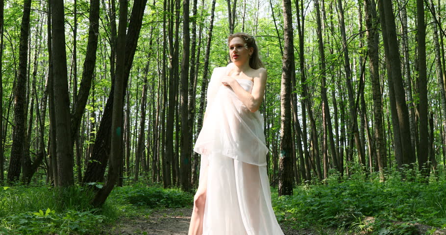 A beautiful girl posing as a nymph in the forest
