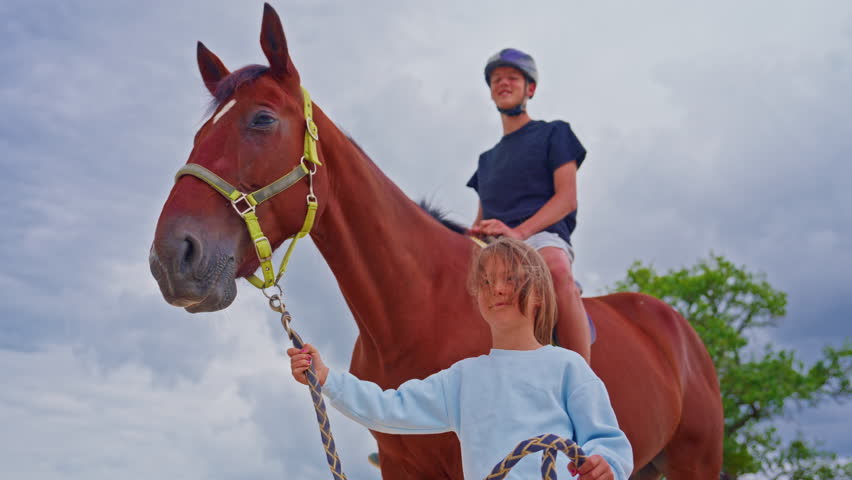 Children interact with the horse in every way during a horseback riding lesson. brother and sister riding a horse together