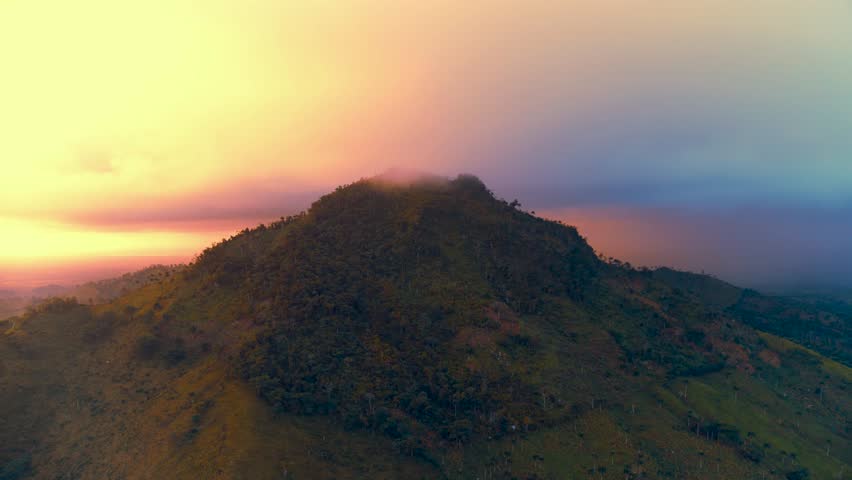 Natural landscape of mountain peak with sunset sky background. Adventure travel concept. Panoramic view of a barren landscape. Vibrant tropical scenery. Green mountain landscape in summer.