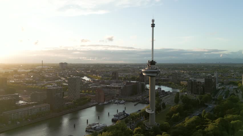 Drone footage of the Euromast observation tower and Rotterdam skyline during the golden hour sunset in summer