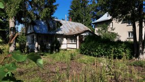 An old rustic cottage surrounded by wild vegetation and trees, bathed in summer sunlight, depicting rural life and nature reclaiming abandoned property. - Powered by Shutterstock - Get 15% off with code: PIKWIZARD15