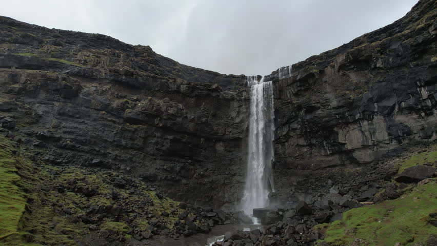 Beautiful Fossa waterfall :Powerful waterfall cascading down a sheer rock face covered with green moss in a stunning landscape