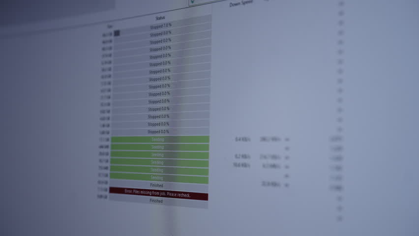 Computer monitor displaying torrent client interface with various files queuing, sending and red error message indicating missing files, representing digital transfer issues and cybersecurity close-up