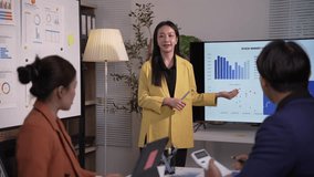 Skilled businesswoman analyzing stock market chart while presenting financial data to colleagues during collaborative corporate meeting at night office - Powered by Shutterstock - Get 15% off with code: PIKWIZARD15