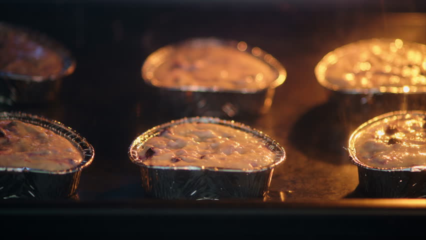 Homemade cottage cheese muffins rising in the oven with golden tops, time lapse