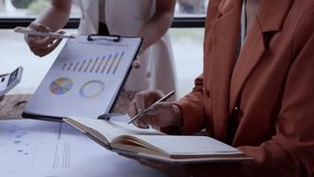 Professional businesswomen analyzing financial charts, collaborating on strategic data insights during team meeting in modern office workspace - Powered by Shutterstock - Get 15% off with code: PIKWIZARD15