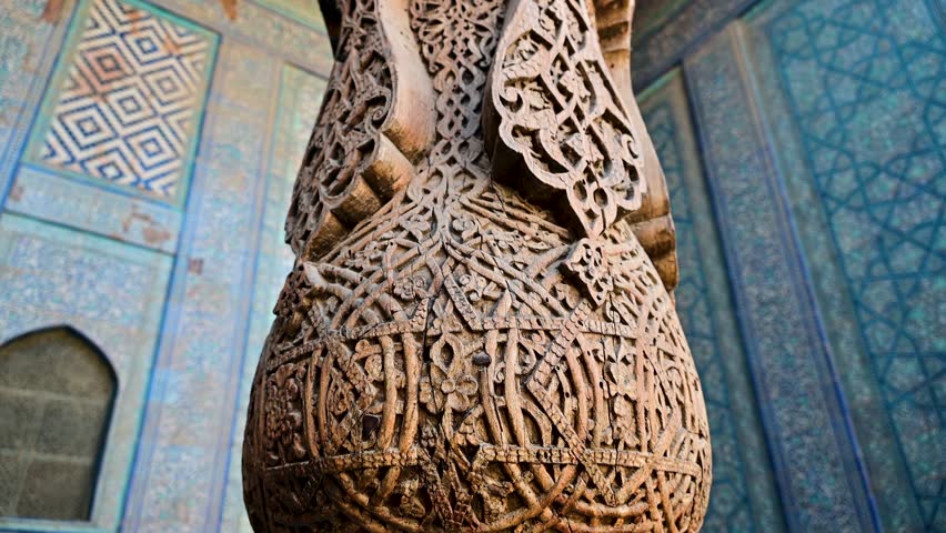 Intricate woodwork details on a column in Toshhovli Palace in Khiva, Uzbekistan