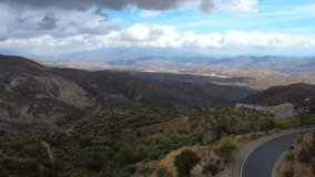 4K aerial video of the countryside near Cádiar in the Sierra Nevada, showing farmland, rolling hills, and rugged mountain scenery under clear skies in Andalusia - Powered by Shutterstock - Get 15% off with code: PIKWIZARD15