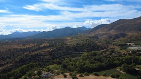 4K aerial video of the countryside near Játar in the Sierra Nevada, showing rolling hills, farmland, and green valleys under clear sunny skies in rural Andalusia. - Powered by Shutterstock - Get 15% off with code: PIKWIZARD15