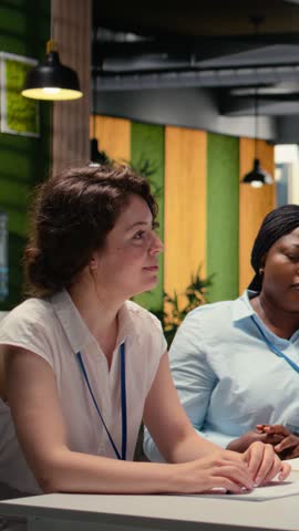 Vertical Video Recruiting team and an applicant engaging in CV evaluation in a business office, discussion about career experience and aspirations for growth. Interview process for professional