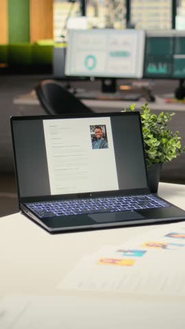 Vertical Video Empty startup space with a laptop running CV applicant before job interview, space used for the recruitment process and reviewing qualifications or past work experience to align with