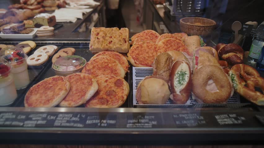 Freshly baked pastries and bread displayed in a bakery shop window with variety of sweet and savory options
