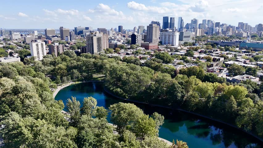 Aerial view of Montreal Parc La Fontaine with greenery and urban grid in the background. g.