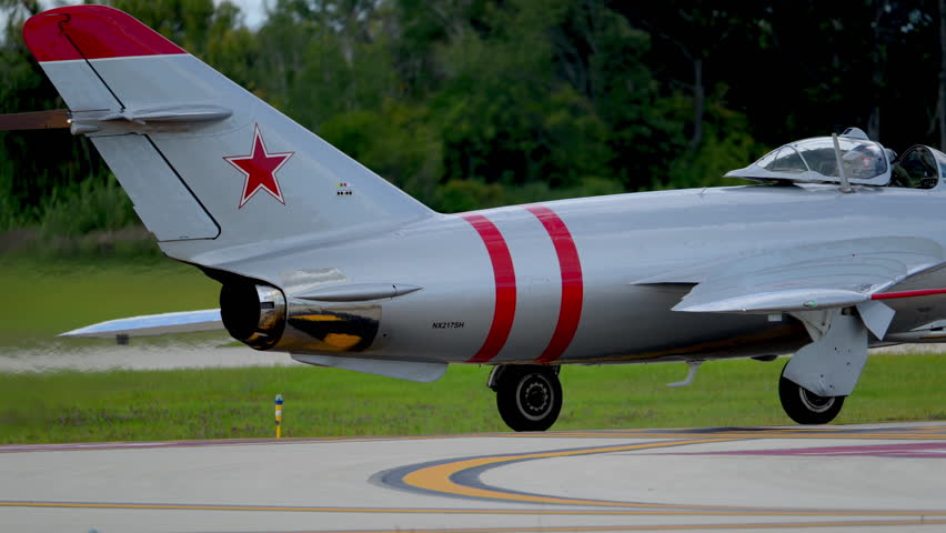 MiG-17 fighter jet taxis to the runway at airshow. Aviation heritage, Cold War history, military technology, aerospace engineering. Waukegan 