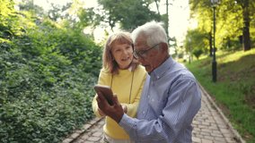On a sunny day in the park, a cheerful diverse elderly couple enjoys a moment together as they explore a smartphone, highlighting their bond and the blend of companionship with modern technology - Powered by Shutterstock - Get 15% off with code: PIKWIZARD15