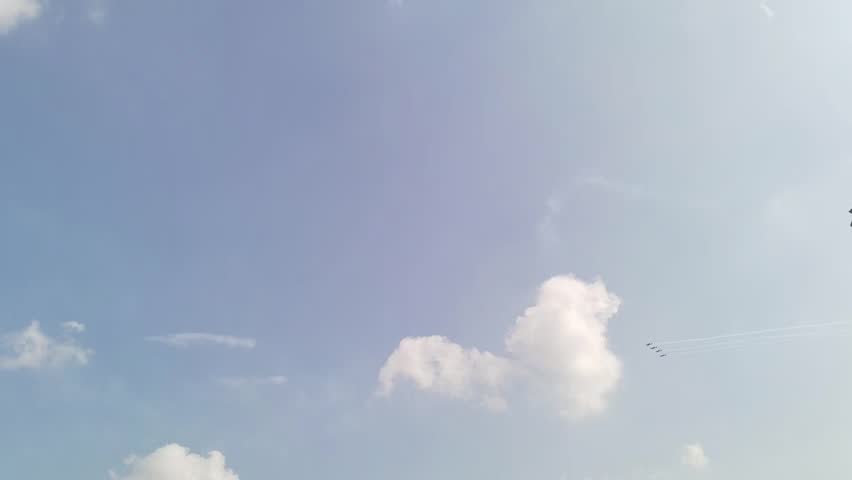 Four fighter jets in a line maneuvering upwards