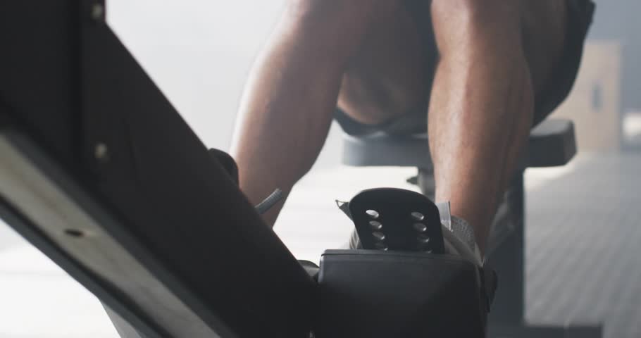 Male rower gripping rowing handle, initiating drive and navigating glitch overlays during fitness. Fitness, digital disruption, workout, motion, sport, athletic, technology