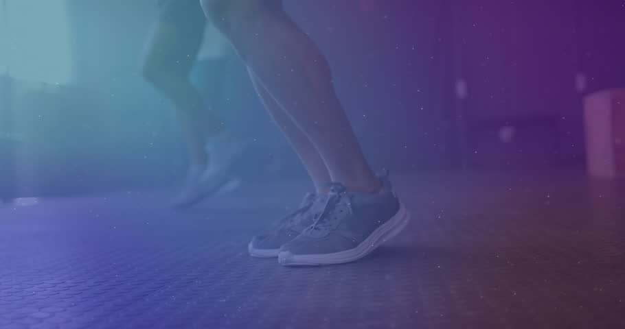 Gym mates jumping on rubber floor and generating neon particles forming DNA helix for fitness. Athletics, motion, energy, innovation, teamwork, visualization, design