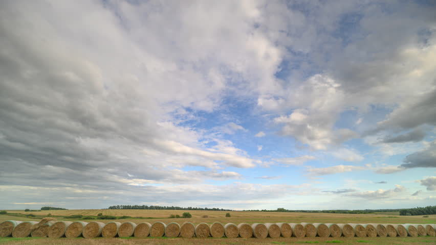 Expansive and Beautiful Landscape Under a Cloudy Sky with Surrounded Hay Bales Present