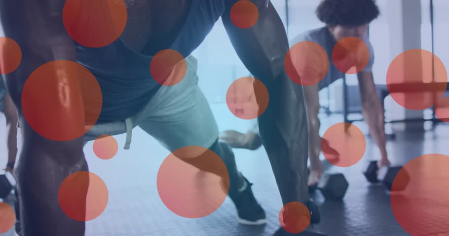 man in blue top initiating renegade row on gym floor while two partners mirroring for strength. Strength, fitness, teamwork, workout, determination, exercise, training