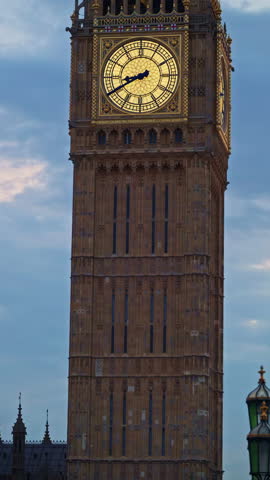 Close-up view of Big Ben illuminated at dusk in London, England. Vertical