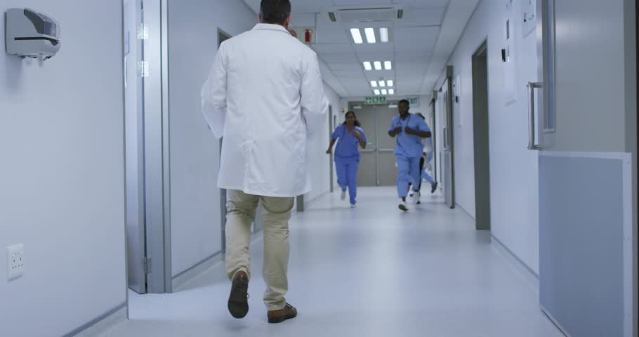 Hospital team sprinting down corridor responding to emergency alert with animated medical overlay. Medics, teamwork, clinical, healthcare, motion, professionalism, modern