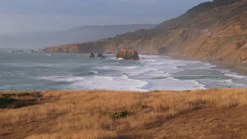 Relaxing view of California Coastline, waves and hills at sunset