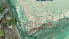 a weathered, cracked, green and white concrete planter corner covered in a multitude of very tiny black ants, highlighting the rough texture and outdoor decay. - Powered by Shutterstock - Get 15% off with code: PIKWIZARD15