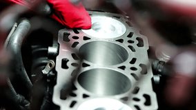 Detail video of mechanic hands cleaning car engine cylinder block with red cloth, wiping edges, channels, and shiny new pistons - Powered by Shutterstock - Get 15% off with code: PIKWIZARD15