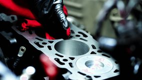Detailed video of mechanic hands cleaning the cylinder block of a Hyundai engine with a red cloth, wiping edges, grooves and shiny new pistons. - Powered by Shutterstock - Get 15% off with code: PIKWIZARD15