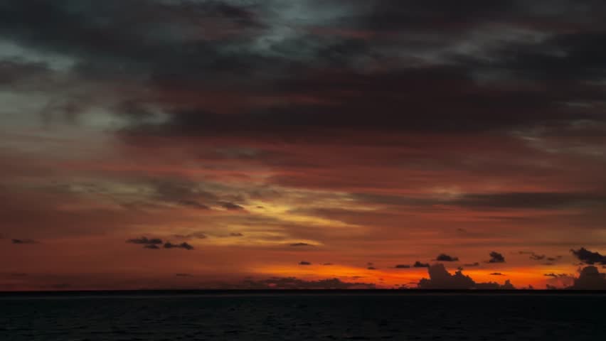 A captivating sunset over the sea, showcasing an orange and pink sky filled with scattered clouds