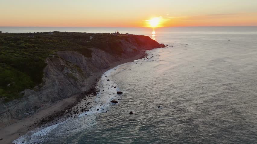 Aerial view of the dramatic Mohegan Bluffs where the lighthouse stands guard, with the sun reflecting off the ocean, New Shoreham, Rhode Island, United States.