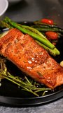 Grilled salmon fillet with asparagus and rosemary on black plate. Close up of roasted salmon served with asparagus, rosemary and sauce on a gourmet plate. - Powered by Shutterstock - Get 15% off with code: PIKWIZARD15
