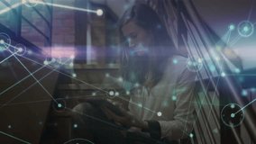 Woman settling on metal stairs and tapping tablet showing network overlay revealing data flow. Technology, connectivity, modern, industrial, innovation, data, telecommunications - Powered by Shutterstock - Get 15% off with code: PIKWIZARD15