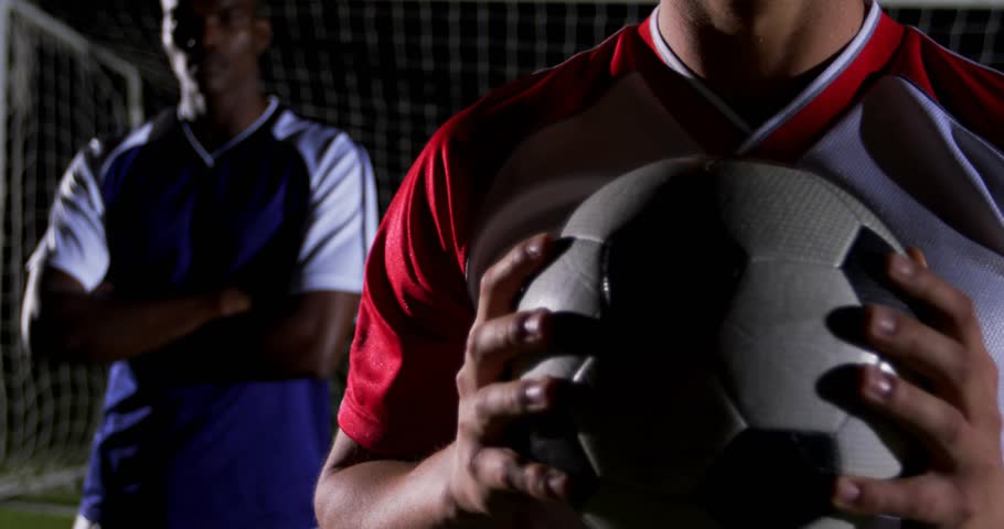 Player holding soccer ball at goal net and initiating alerts showing rising social media engagement. Athletes, teamwork, digital, broadcast, outdoor, energetic, competition