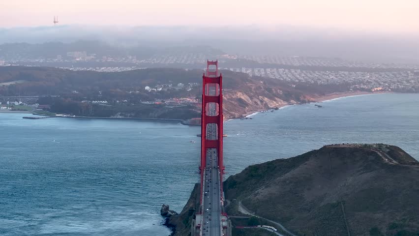 Aerial view of the Golden Gate Bridge spanning across the water, with the cityscape fading into the horizon, a blend of urban and natural beauty, San Francisco, California, United States.