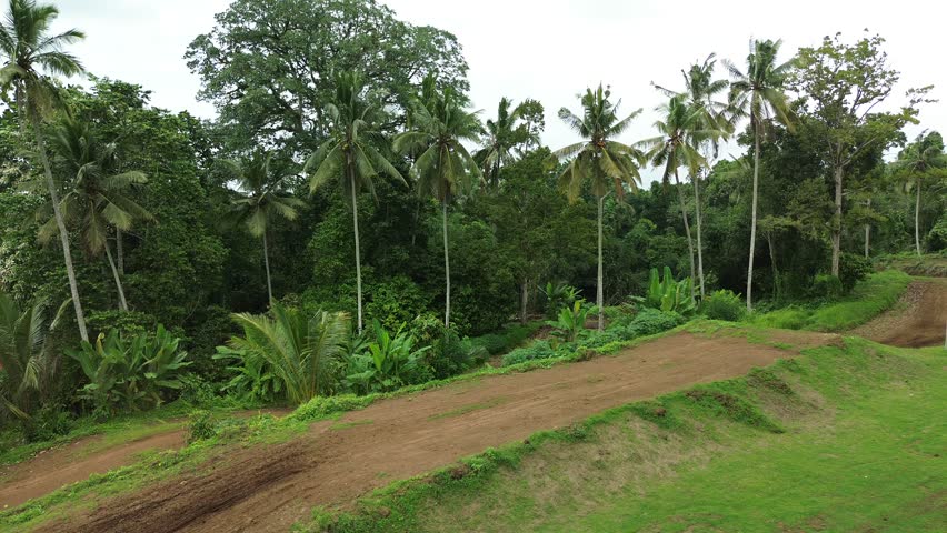 An aerial view of enduro motocross. Riders compete on the trail in the off-road category. Riders train on motorcycles, jumping up and down hills at high speed and performing tricks.