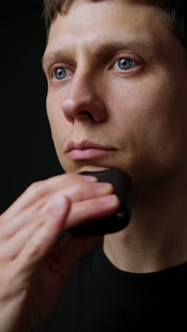 Modern electric shaver close up in use, compact grooming technology and innovation. Vertical Video