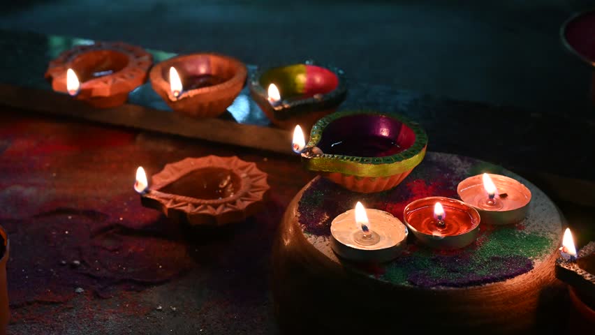 Beautiful Diwali Greeting using Diya or clay oil lamp lit and arranged over Rangoli