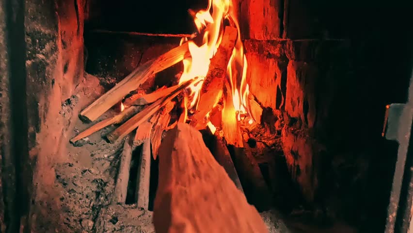 Firewood lies a fireplace. Complex firewood light up and gradually turn into brightly, when the fire becomes stronger, creating dynamic luminous light and bright orange sparks