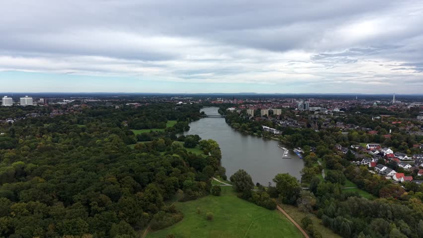 Natural lake near Americans neighborhood at cloudy day. Aerial panorama view. Green trees in late summer with dense clouds at sky.