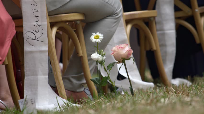 Guest sitting on wooden chairs on wedding day