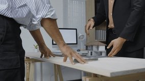 Professional architect presenting architectural scale model of residential house to client during successful business meeting, culminating in partnership handshake in modern office environment - Powered by Shutterstock - Get 15% off with code: PIKWIZARD15