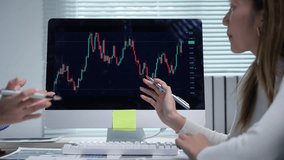 Corporate professionals analyzing stock market data on computer screen, collaborating and strategizing together in modern office environment - Powered by Shutterstock - Get 15% off with code: PIKWIZARD15