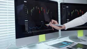 Businesswoman pointing at computer screen displaying stock market data with candlestick chart and line graph, analyzing investment opportunities - Powered by Shutterstock - Get 15% off with code: PIKWIZARD15
