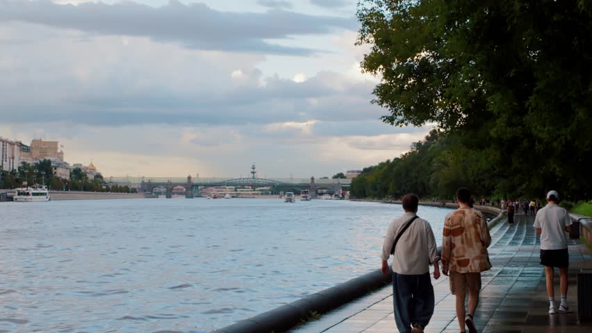 People walking on riverside promenade after summer rain