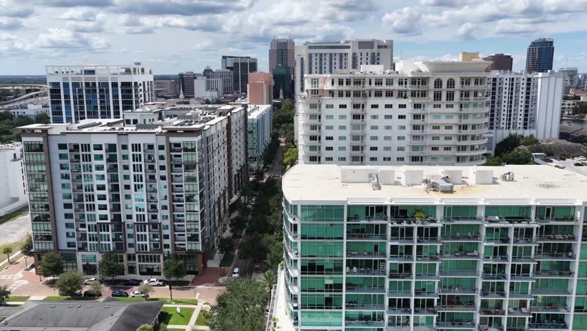 Orlando, Florida, United States – September 25, 2025: Aerial view of downtown Orlando on a sunny day. Footage shows high-rise buildings, Lake Eola, city streets, and surrounding urban areas.