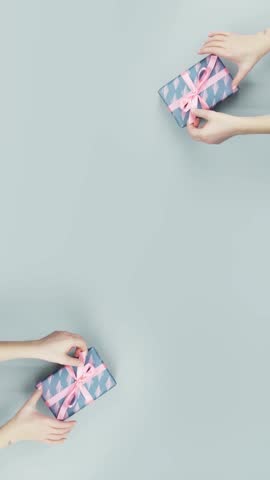 Boomerang video of hands untying the ribbon of a beautifully wrapped gift box, creating a festive and joyful celebration moment.
