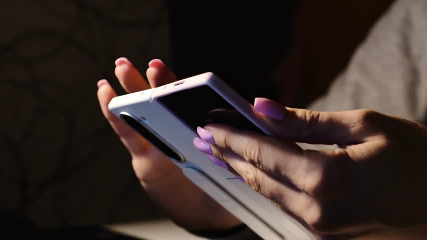 Close up of woman using fold phone symbolizing data privacy and cyber threats